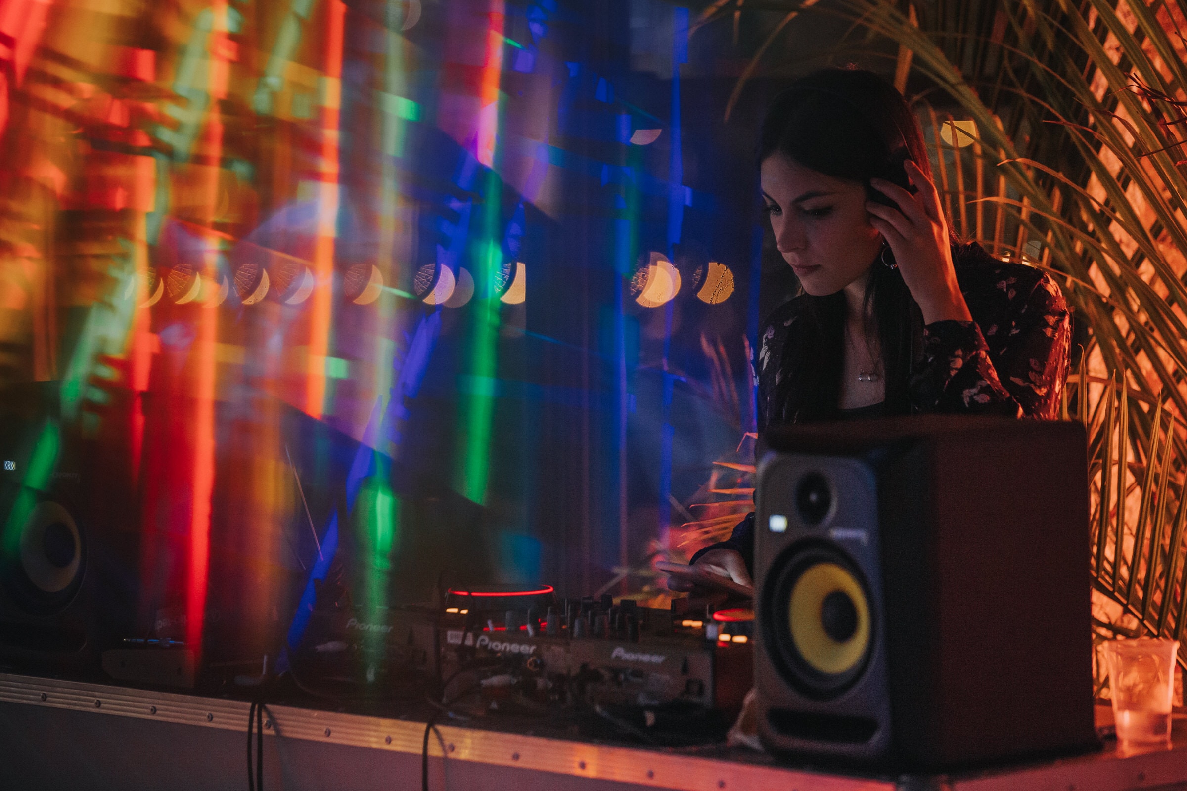 DJ mixing on Pioneer decks under colorful streaking lights at Colony Nights NYC.